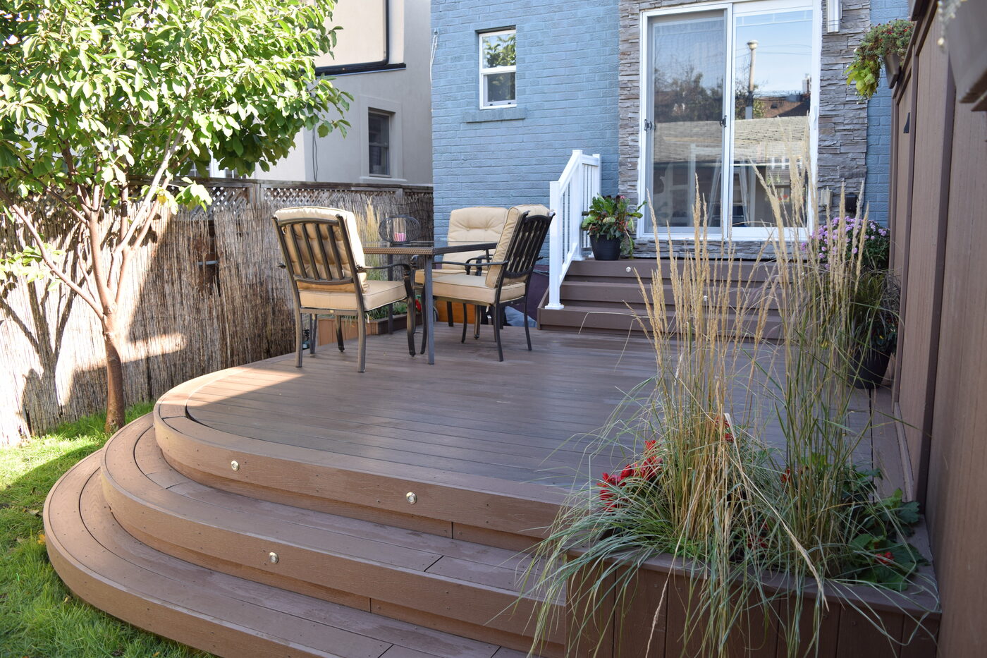 Curved composite deck steps leading to a compact backyard seating area