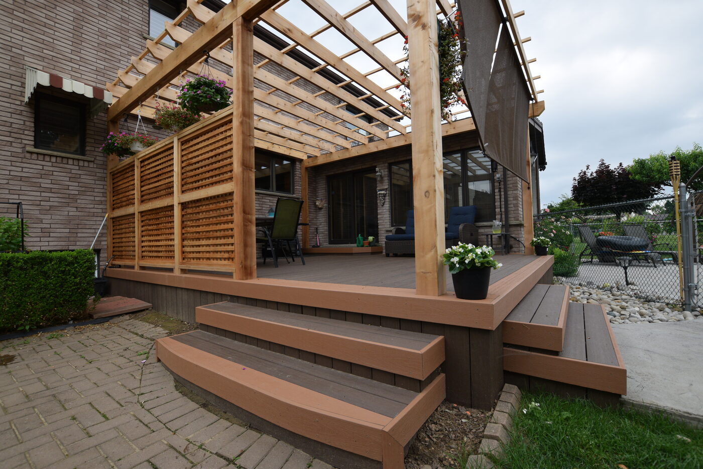 Composite deck with pergola framing, privacy screen, and layered steps
